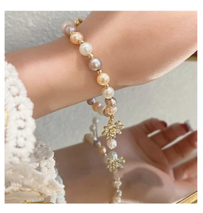 Detail view of a colorful freshwater pearl bracelet with a sunflower zircon pendant