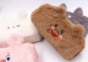 Detail of plush animal pencil cases in rabbit and bear styles with soft faux fur texture