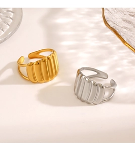 Detail of minimalist 18K gold and silver plated wavy adjustable rings with soft lighting