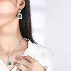 Luxury emerald-cut green gemstone jewelry set with necklace and earrings on model