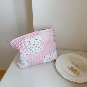 Détail d'une trousse à maquillage matelassée rose à fleurs avec motif de patchwork