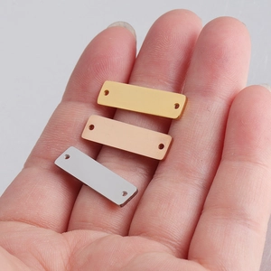 Detailed view of rectangle stainless steel charms in gold, rose gold, and silver finishes