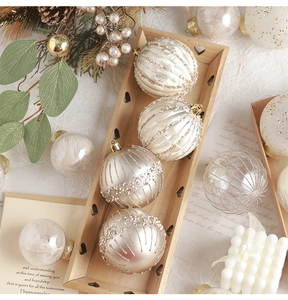 Detail of elegant champagne and white Christmas ornaments on a wooden heart tray