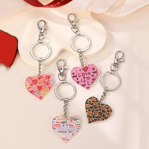Acrylic heart keychains with colorful patterns and love quotes on soft background