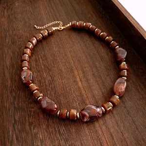 Collier ethnique avec perles en résine ambrée marbrée et entretoises en métal doré