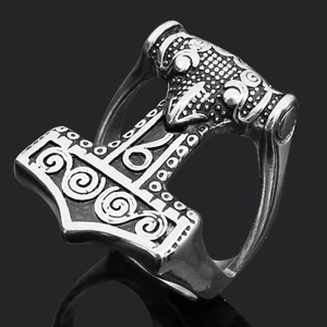 Detailed view of silver Viking Mjölnir ring with wolf head on a black reflective surface