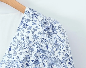 Detail shot of blue and white floral puff sleeves with pleated shoulder design
