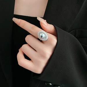Close-up of elegant silver open ring featuring a large pearl and micro-paved zircons