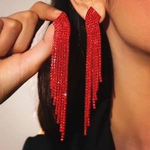 Macro detail of long red rhinestone tassel earrings showing length and brilliant shine