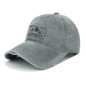 Detail of distressed grey cotton baseball cap with embroidered mountain patch and GOGQUEST logo