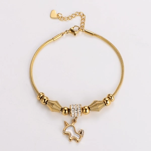 Macro detail of golden unicorn charm bracelet with mother of pearl and crystal beads