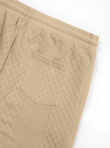 Detail of khaki casual shorts with geometric jacquard texture and elastic waistband