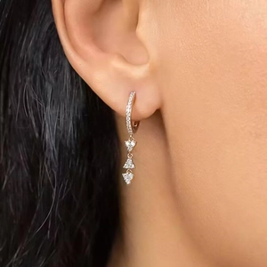 Elegant gold drop earrings with tiered sparkling cubic zirconia triangles on model