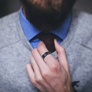 Men's matte black titanium steel ring with hammered texture worn by a male model