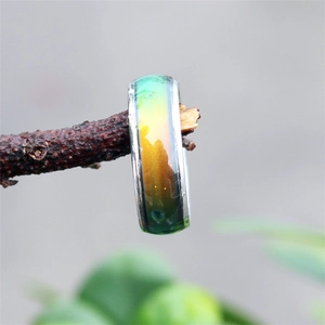 Detail of color-changing mood ring on a natural branch with vibrant gradient effect