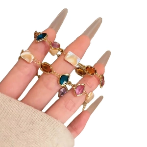 Colorful square glass shell bracelet with gold chain shown on a model's wrist