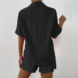 Détail de l'ensemble noir deux pièces avec chemise à manches courtes et short gaufré
