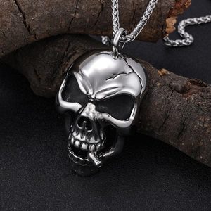 Mens stainless steel hollow skull pendant necklace on rustic wood with black background