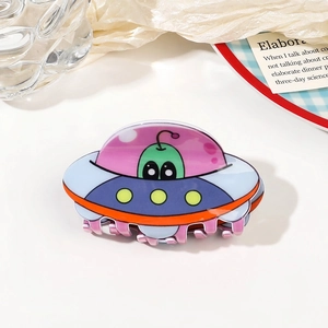 Macro detail of acrylic UFO spaceship hair claw with colorful alien design for styling