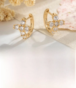 Detail of light coffee gold cross hoop earrings with sparkling cubic zirconia stones