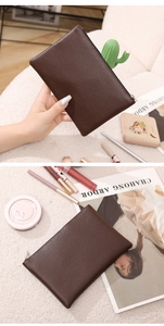 Macro detail of dark brown lychee texture PU leather and metal zipper on slim makeup bag