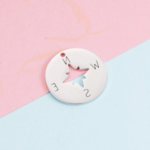 Close-up of 22mm stainless steel compass pendant with N E S W engraved direction letters