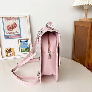 Side view of pink leather backpack featuring silver hardware on a white desktop