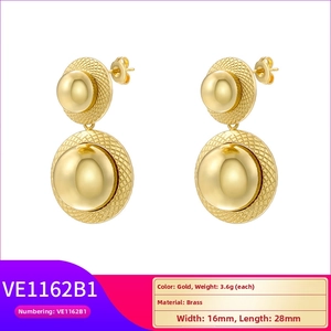 Detail of gold geometric brass earrings featuring polished spheres and grid texture