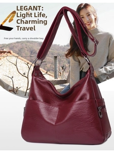 Macro shot of burgundy faux leather texture and adjustable shoulder strap on cross-body bag