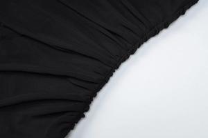 Detailed close-up of ruched black mesh fabric texture and elastic seam stitching on dress
