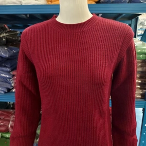 Dettaglio dell'abito in maglia rossa con scollo rotondo e trama a coste verticali