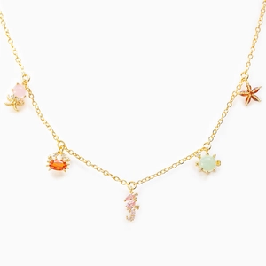Golden necklace with colorful zircon marine animal pendants on a clean white background