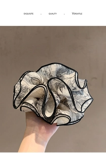 Detalle de coletero grande de gasa con estampado floral negro y ribetes de contraste