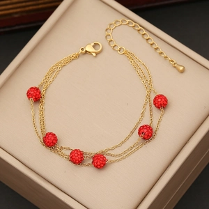 Bracciale a tre strati in acciaio dorato con sei sfere di strass rossi lucidi