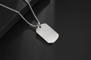 Detail of titanium steel dog tag pendant with shell inlay on a classic box chain