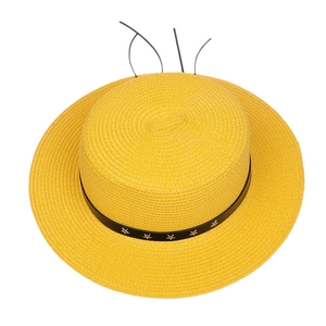 Detail view of woven straw hat featuring black band with silver stars and ear accents