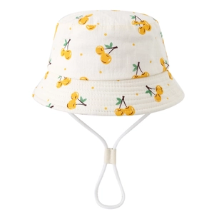 Close-up of baby sun hat featuring yellow cherry patterns and adjustable white wind strap