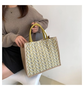 Detail of a large jute tote bag with a geometric V-pattern and yellow straps in a lifestyle setting