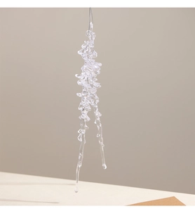 Macro shot of transparent acrylic icicle ornaments with silver hanging strings for Christmas