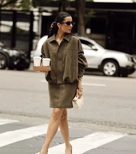 Detail of olive green suede jacket and skirt set with high-quality fabric texture