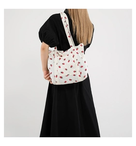 Detailed view of large white tote bag with red strawberry print on corduroy fabric
