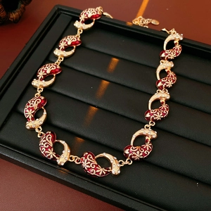 Macro detail of vintage gold bracelet with red enamel inlay and crystal flowers