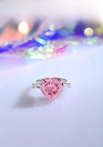 Macro shot of heart-shaped pink zircon ring with baguette side stones in silver setting