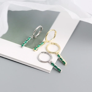 Detail view of gold and silver S925 earrings with rectangular green zircon stones