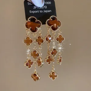 Gold plated four-leaf clover drop earrings with amber crystals and elegant long tassels
