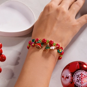 Detail of Christmas bracelet with Santa, bell and tree charms on a model's wrist
