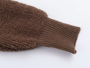Close-up of brown textured bouclé knit cuffs on a pilot bomber jacket detail
