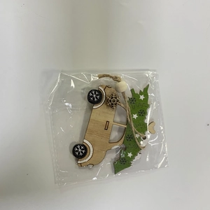 Detail of wooden Christmas car ornament with tree and snowflake wheels in polybag