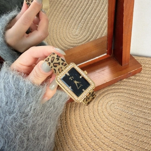 Detail of square gold diamond watch featuring a bold leopard print strap and dark dial