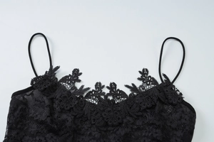 Détail de l'encolure en dentelle noire avec maille délicate et fines bretelles pour femme
